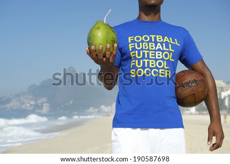 Brazilian soccer player in multi language message t-shirt holding football and drinking coco verde coconut Rio de Janeiro