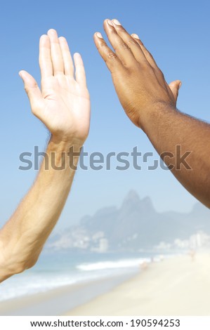 Brazilian diversity interracial hands high five Ipanema Beach Rio de Janeiro Brazil
