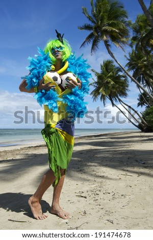 Funny Brazilian soccer fan fondling his or her soccer balls on tropical beach