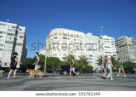 RIO DE JANEIRO, BRAZIL - FEBRUARY 7, 2014: Residents and pets get some early morning exercise along the boardwalk at Copacabana Beach.