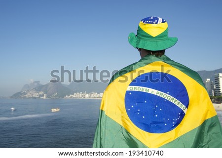 Brazilian football soccer player wearing flag and hat in front of Rio de Janeiro Brazil skyline