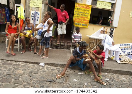SALVADOR, BRAZIL - FEBRUARY 27, 2014: Young Brazilians socialise on the cobblestone street of Pelhourinho as preparations gear up for Carnaval celebrations.