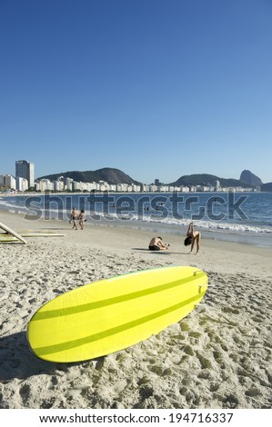 Yellow stand up paddle long board surfboard on Copacabana Beach Rio de Janeiro Brazil