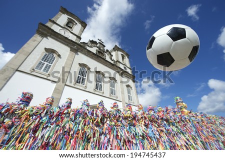 Football soccer ball in the air above wall of Brazilian wish ribbons at the Bonfim church in Salvador Bahia Brazil