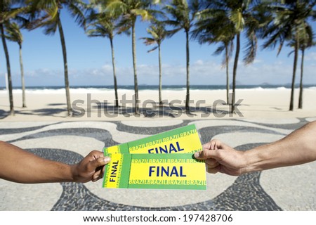 Hands holding two Brazil final tickets to football soccer event in Copacabana Rio de Janeiro Brazil