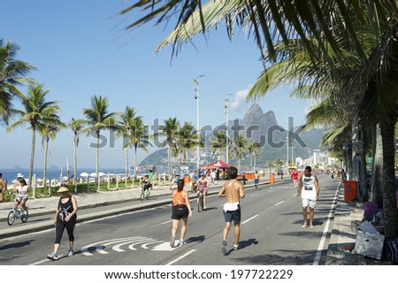 RIO DE JANEIRO, BRAZIL - JANUARY 26, 2014: Residents exercise on the beachfront road Avenida Vieira Soto in Ipanema Beach, which is closed to vehicles on Sundays.