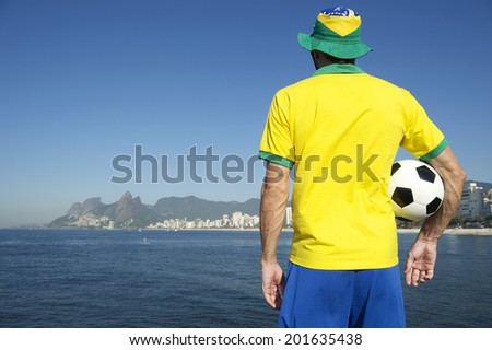 Brazilian man in team Brazil kit celebrating on tropical Ipanema Beach Rio de Janeiro