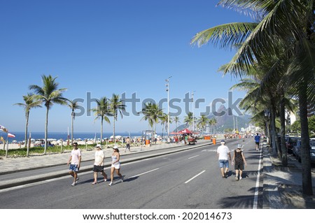 RIO DE JANEIRO, BRAZIL - JANUARY 26, 2014: Active residents walk on the beachfront road Avenida Vieira Soto in Ipanema Beach, which is closed to vehicles on Sundays.