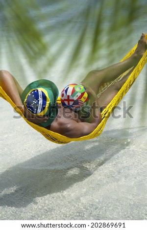 Brazilian football player relaxing in beach hammock with international team flag soccer ball