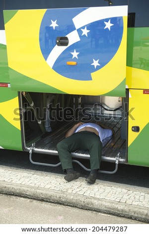 RIO DE JANEIRO, BRAZIL - OCTOBER 19, 2013: Brazilian bus driver takes a nap inside the luggage hold of his vehicle parked on Copacabana Beach.