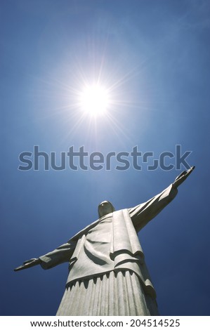 RIO DE JANEIRO, BRAZIL - OCTOBER 20, 2013: Statue of Christ the Redeemer, a symbol of the city, stands at the peak of Corcovado Mountain under bright tropical sun.