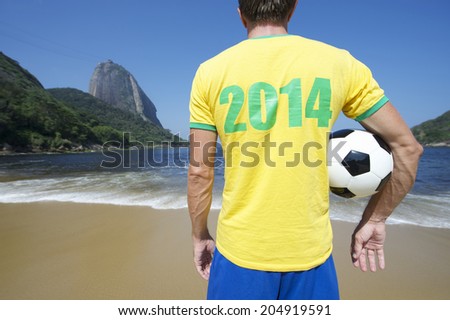 Brazilian football player in 2014 shirt standing with soccer ball at Sugarloaf Pao de Acucar in Rio de Janeiro Brazil