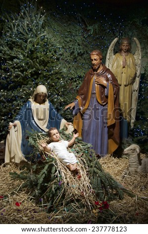 Christmas nativity scene with Mary, Joseph, and the Angel Gabriel looking down on baby Jesus in his manger
