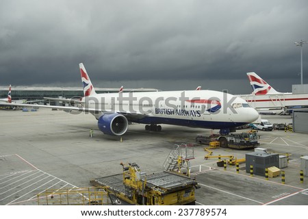 London, UK - October 31, 2013: British Airways passenger planes stand at their gates under dark skies at Heathrow Airport.