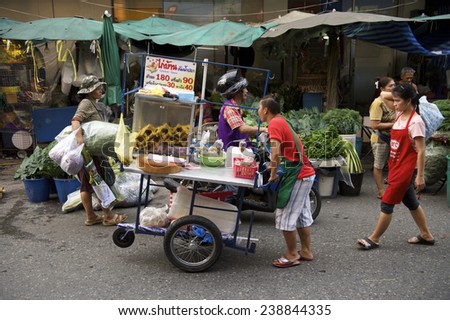 BANGKOK, THAILAND - OCTOBER 27, 2014: Vendors work to keep their stalls running at an outdoor fruit and vegetable market in the city center.
