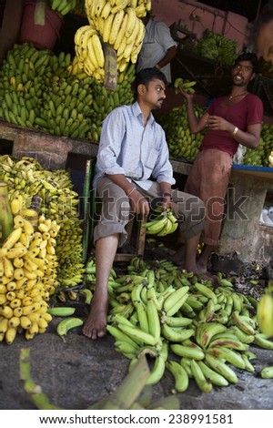 MYSORE, INDIA - NOVEMBER 4, 2012: Indian vendors tend to their banana stall in the Devaraja fruit market.