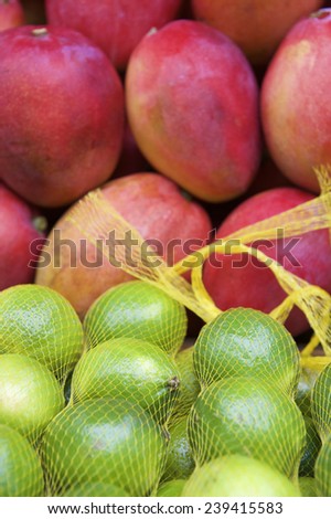 Fresh red mangoes and shiny green limes at outdoor Brazilian tropical farmers market in Rio de Janeiro Brazil