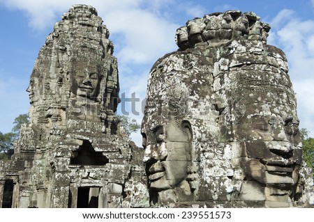 Angkor Wat Temple of Bayon stone face sculpture green trees blue sky
