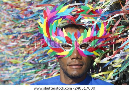 Salvador Carnival scene features Brazilian man in colorful mask with wish ribbons