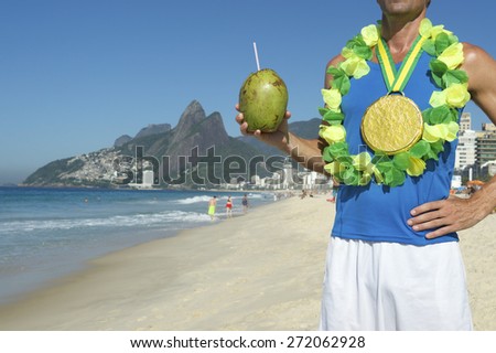 Gold medal athlete wearing celebrating winning with coconut on Ipanema Beach Rio de Janeiro Brazil