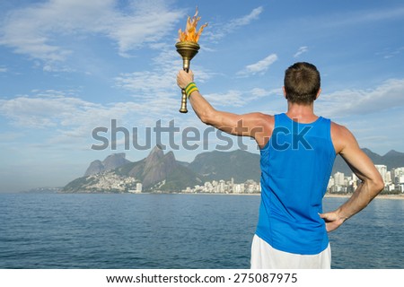 Athlete in in athletic uniform standing with sport torch above Rio de Janeiro Brazil skyline at Ipanema Beach