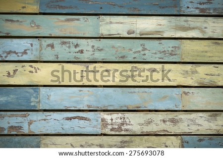 Weathered wood plank grunge background in chipped and peeling blue and yellow colored paint