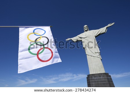 RIO DE JANEIRO, BRAZIL - CIRCA MARCH, 2015: Olympic flag hangs in clear blue sky next to the statue of Christ the Redeemer.