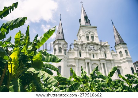 New Orleans famous church spires of the Cathedral Basilica of Saint Louis with banana palms under sunny blue sky in the French Quarter