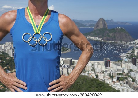 RIO DE JANEIRO, BRAZIL - MARCH 05, 2015: Athlete wearing Olympic rings gold medal above city skyline view of Sugarloaf Mountain and Guanabara Bay.