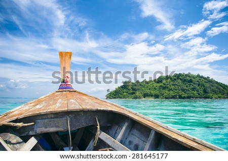 Traditional Thai wooden longtail boat heads toward the tropical Andaman shores of Bamboo Island, a popular day trip from Koh Phi Phi