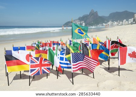 International flags fly with Brazilian flag on the sand against a skyline view of Ipanema Beach in Rio de Janeiro, Brazil