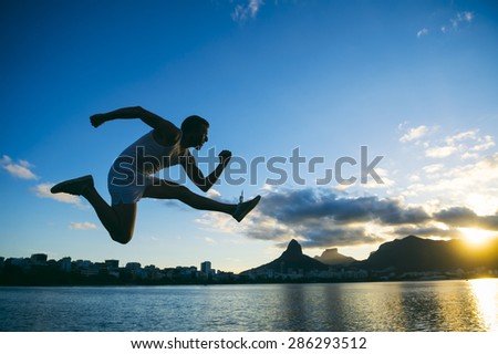 Silhouette of athlete jumping in front of the sunset skyline at Lagoa lagoon in Rio de Janeiro, Brazil