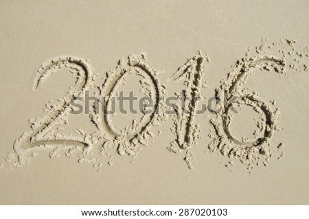 Simple 2016 message handwritten in clean numbers on smooth sand beach in Rio de Janeiro Brazil