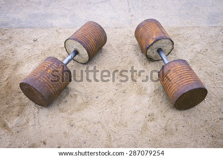 Homemade Brazilian dumbbell weights made from concrete inside rusted food cans at an outdoor gym at Arpoador Beach, Rio de Janeiro, Brazil