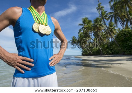 First place Brazilian athlete standing with gold medals on empty beach