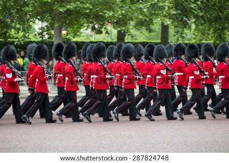 Queen\'s foot guards marching in formation down The Mall in a royal Trooping the Colour ceremony in London England