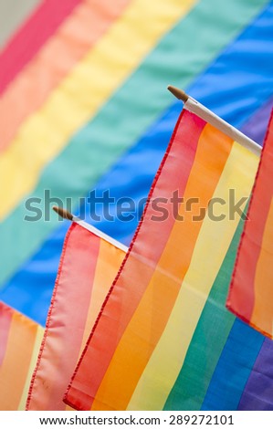 Gay pride rainbow flags fill the frame for a colorful background