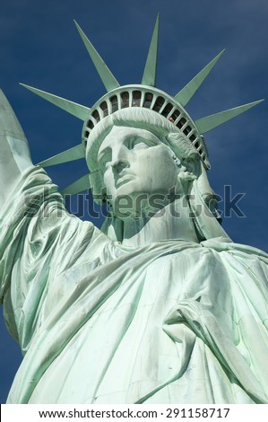 Statue of Liberty close-up vertical profile with crown against blue sky