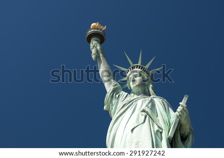 Front view of the Statue of Liberty holding her torch against clear bright blue sky