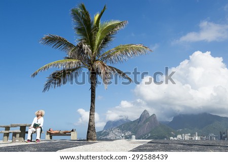 RIO DE JANEIRO, BRAZIL - FEBRUARY 21, 2015: Residents relax in the morning sun at Arpoador, a popular lookout at the end of Ipanema Beach.