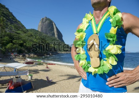 Champion athlete wearing Brazil colors lei around his gold medal flip flop celebrating at Red Beach Rio de Janeiro Brazil