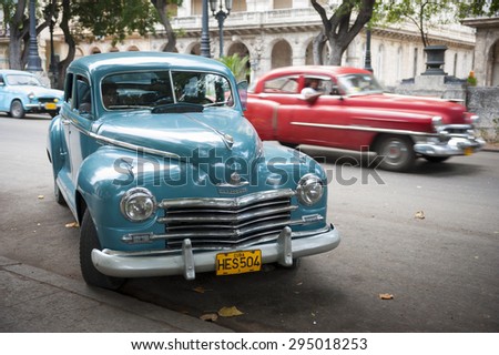 HAVANA, CUBA - JUNE, 2011: Vintage American taxi cars share the road on the Paseo del Prado in Central Havana.