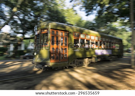 Streetcar tram running through the leafy Garden District of New Orleans at sunset