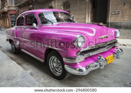 HAVANA, CUBA - JUNE, 2011: Bright pink refurbished vintage American car stands parked on quiet street in Centro, Havana Cuba