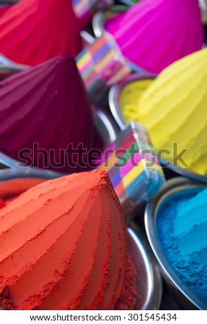 Colorful piles of Indian bindi powder dye at outdoor local Devaraja Market in Mysore India blue, yellow, red, and pink,