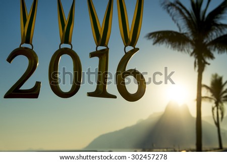 Golden 2016 medals hang from Brazil color ribbons above the Ipanema Beach sunset skyline in Rio de Janeiro, Brazil