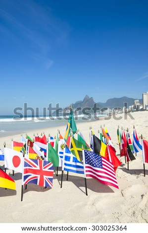 International flags fly with Brazilian flag on the sand against a skyline view of Ipanema Beach in Rio de Janeiro, Brazil