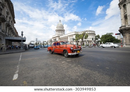 HAVANA, CUBA - JUNE, 2011: Classic American Cuban vintage taxi car passes in front of the Capitolio building in Central Havana.