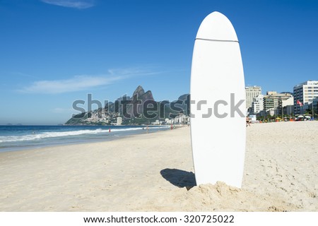Stand up paddle long board surfboard stuck in the sand on Ipanema Beach Rio de Janeiro