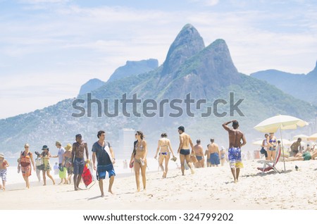 RIO DE JANEIRO, BRAZIL - JANUARY 20, 2013: Two Brothers Mountain dominates the view of beachgoers on the shore of Ipanema Beach.